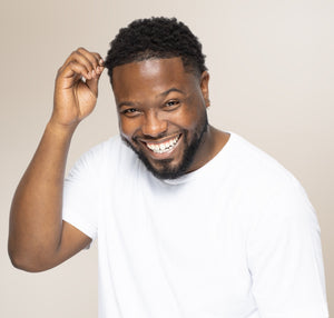 Confident Black man smiling after starting trichology hair restoration in Atlanta